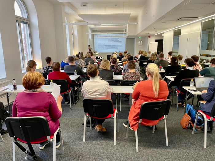 Conference scene with attendees seated facing a speaker at BuddyCare annual customer event in Helsinki.