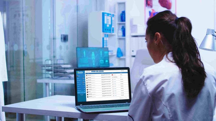 Nurse working on a computer using pathway management dashboard