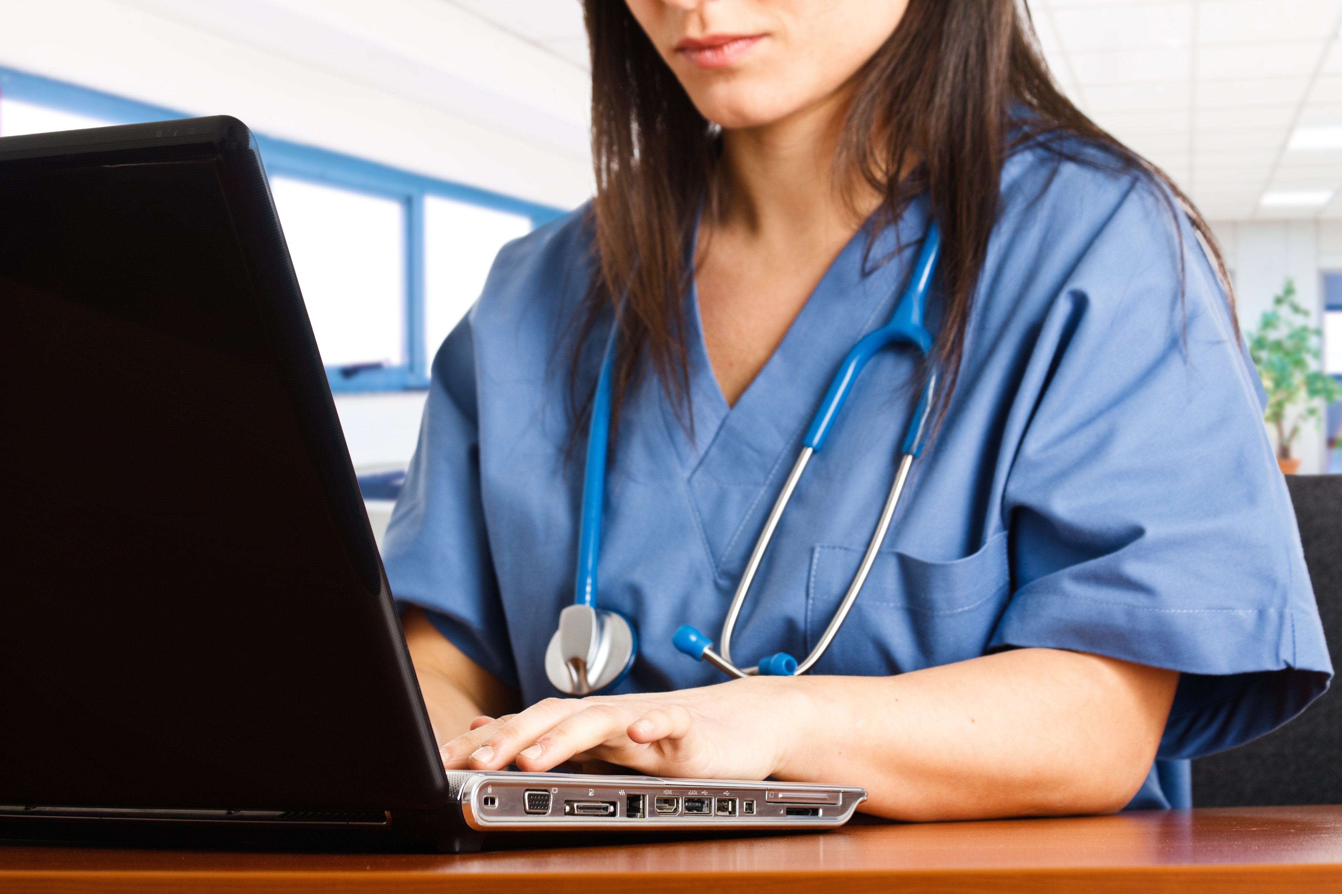Nurse using a laptop for remote patient monitoring