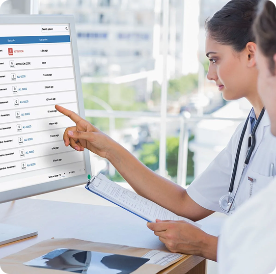 Two doctors are reviewing patient questionnaires on a clinical dashboard for care process improvement.